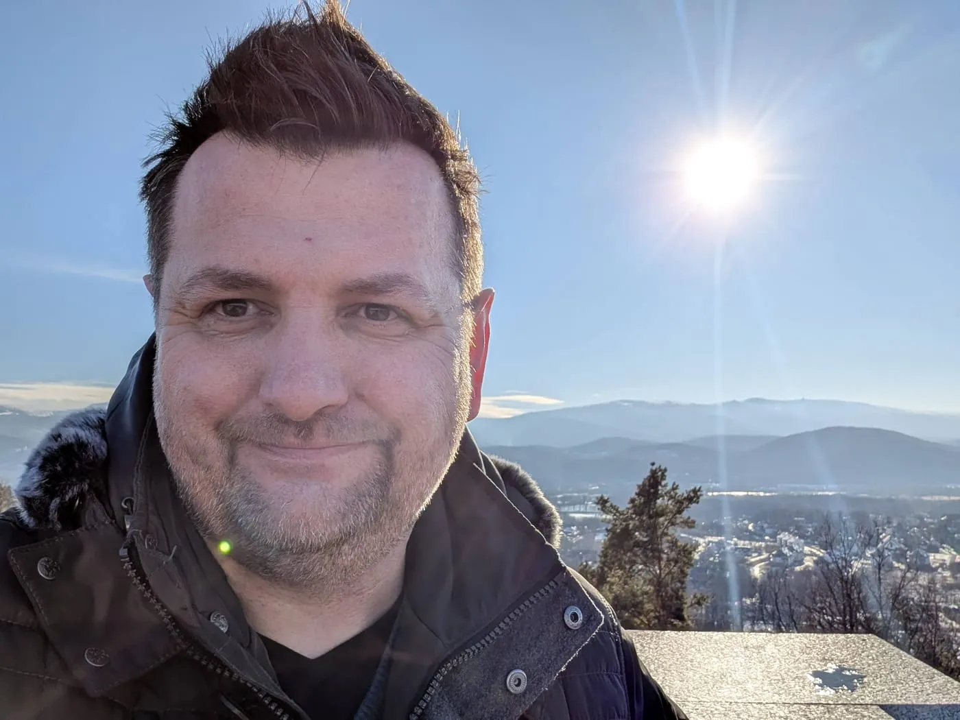 Marcin Roszak na tarasie widokowym wieży na Sołtysiej Górze, w tle Karkonosze